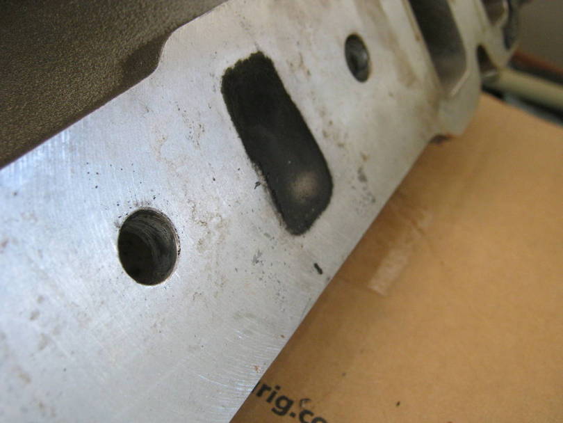 Looks like a hole. It is a char mark from the burned gasket. I expected thi