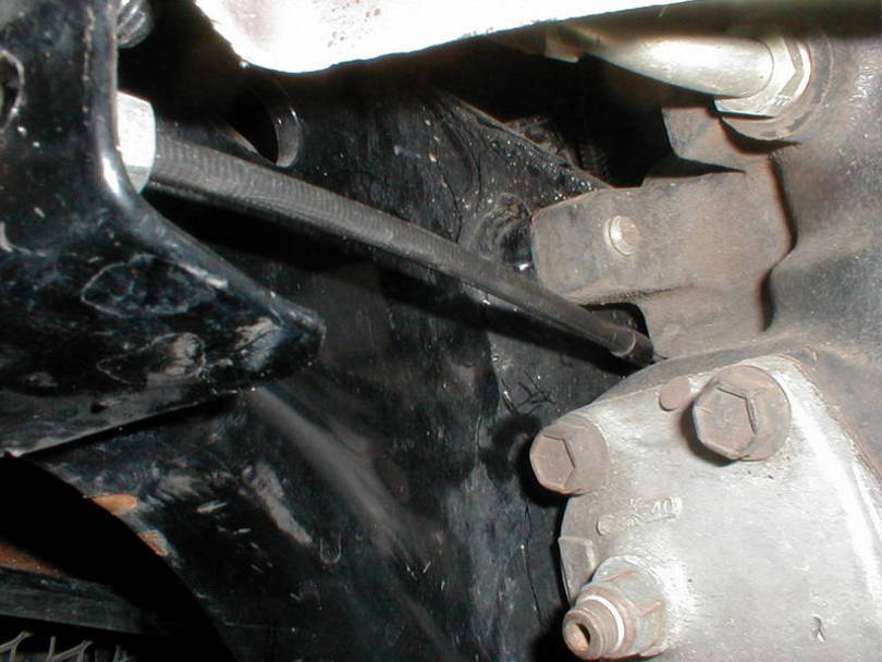 The cable runs between the frame and the steering box.