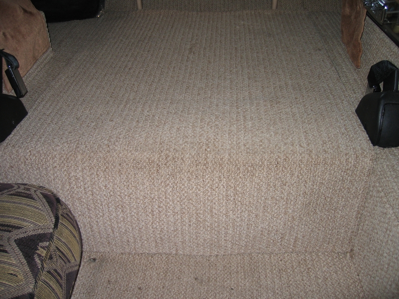 Carpeted hatch closed with latches concealed.