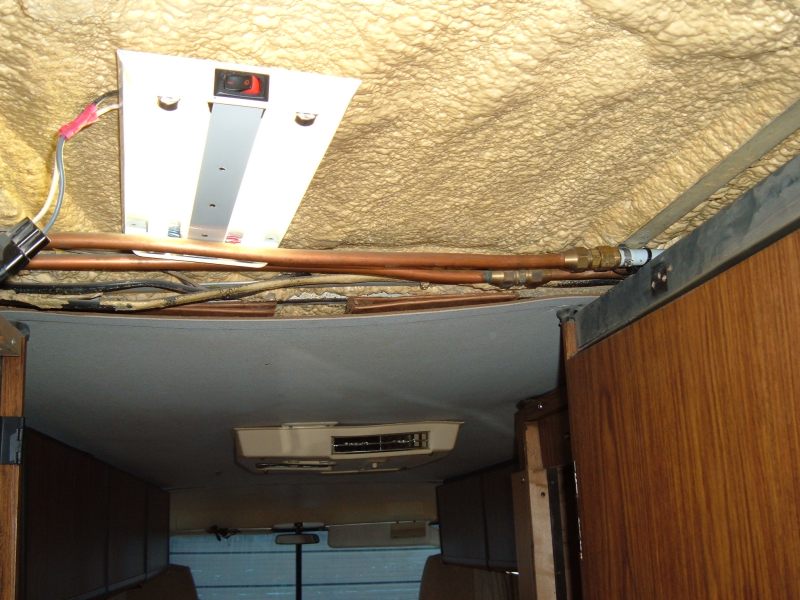 Copper pipes go across the hall behind the ceiling panel